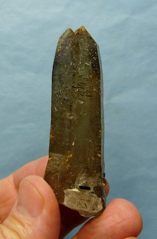 Light smoky quartz crystal with minute schorl needles on its surface
