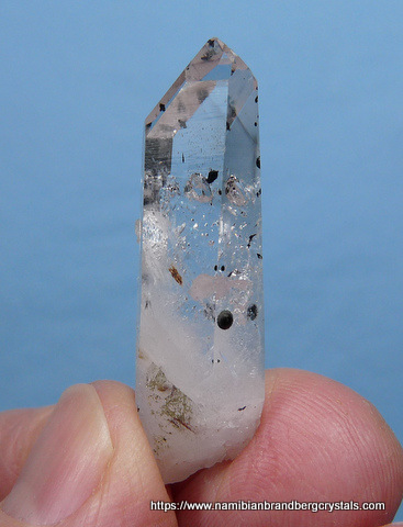 Clear quartz crystal with small pumpellyite balls inside and outside