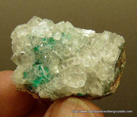 Gemmy calcite crystals with bits of dioptase, on matrix