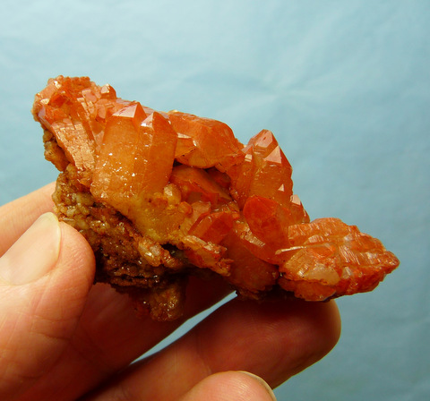 Quartz crystals with orangy-brown hematite colouring, on matrix